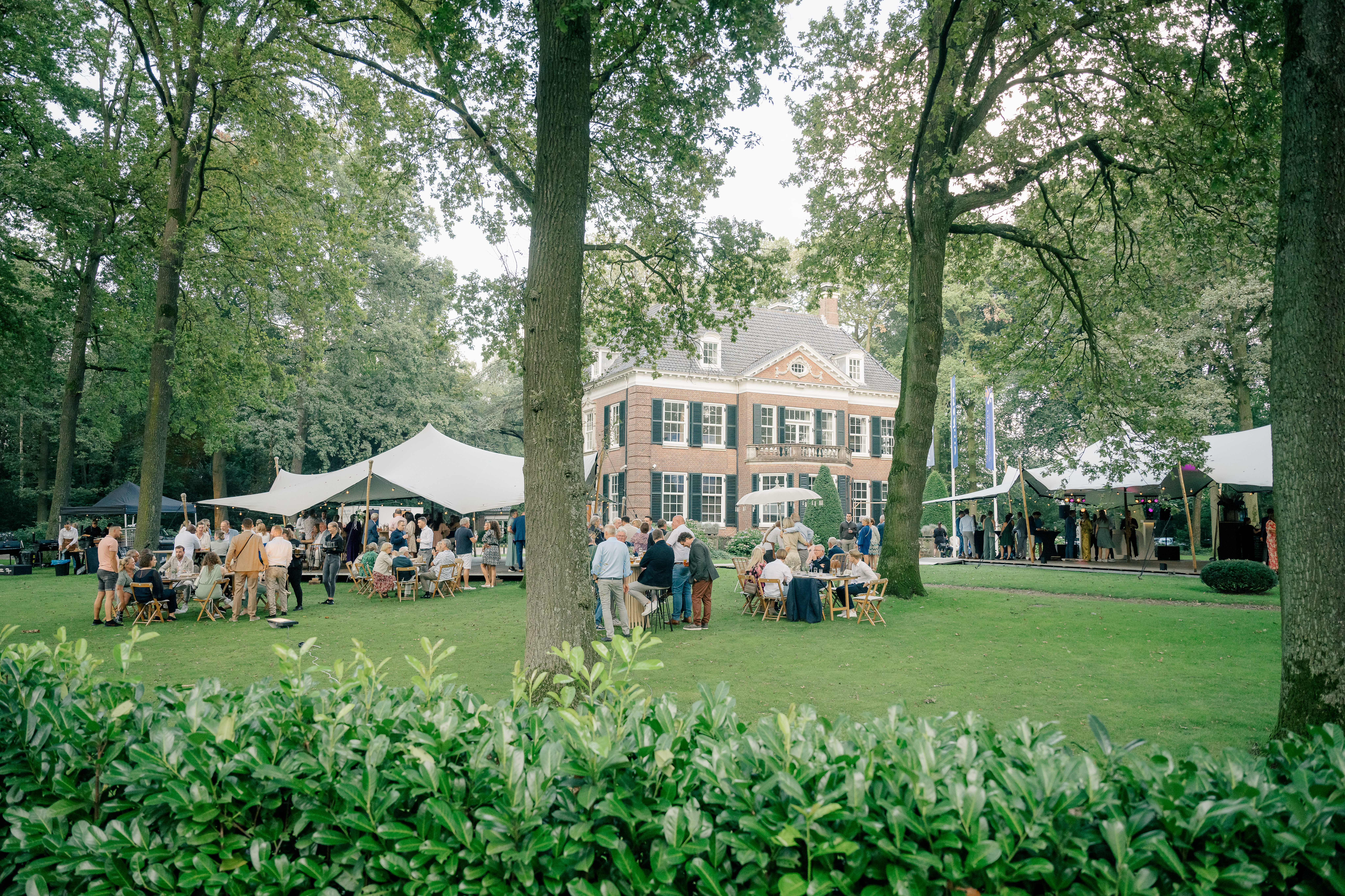 landscape photo of outdoor september wedding on the shaded grounds of a villa in Helmond with white tents set up
