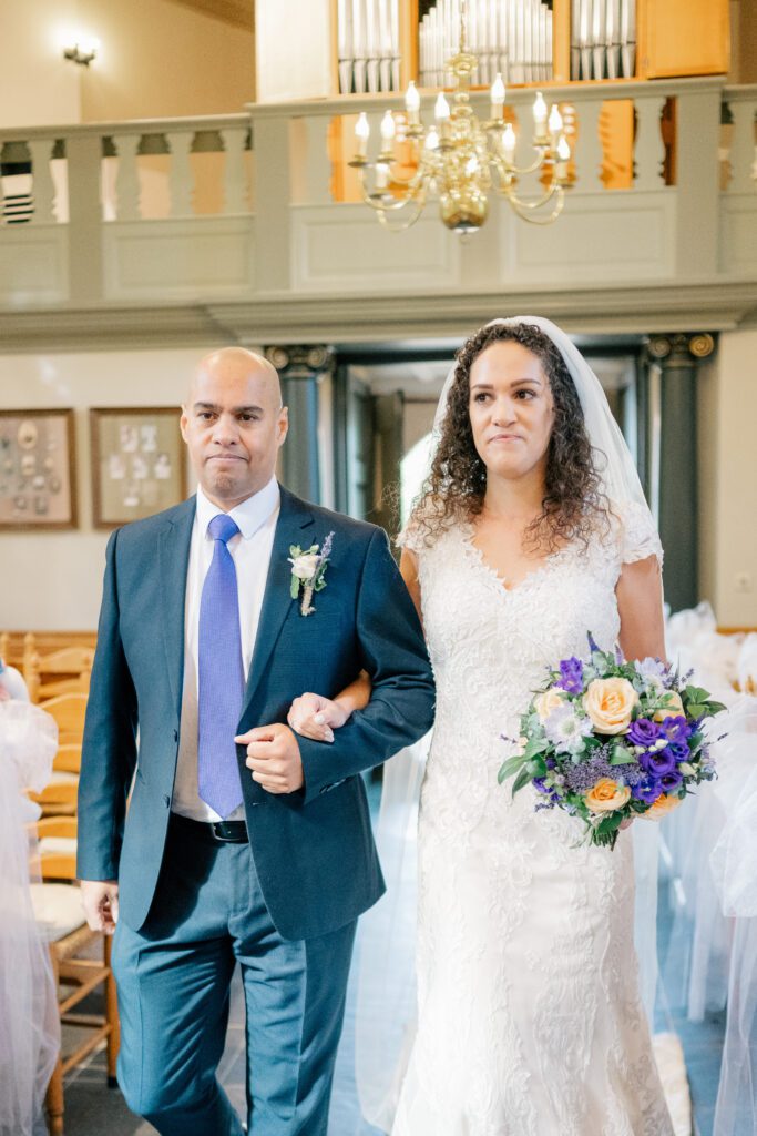 Father of the bride and bride walking down the aisle of the Van Goghkerkje in Nuenen